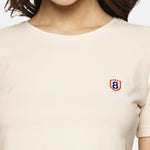 Close-up of beige women’s spandex crop top, showing fabric texture and stitching details.