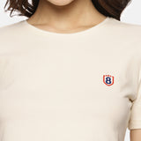 Close-up of beige women’s spandex crop top, showing fabric texture and stitching details.