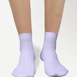 Side view of ankle high nylon white socks, highlighting snug fit and stretchable material.