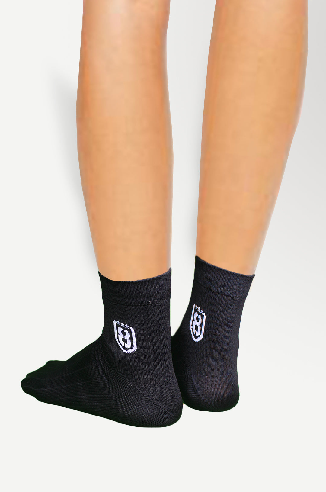 Back view of black nylon socks, featuring durable construction and moisture-wicking material.