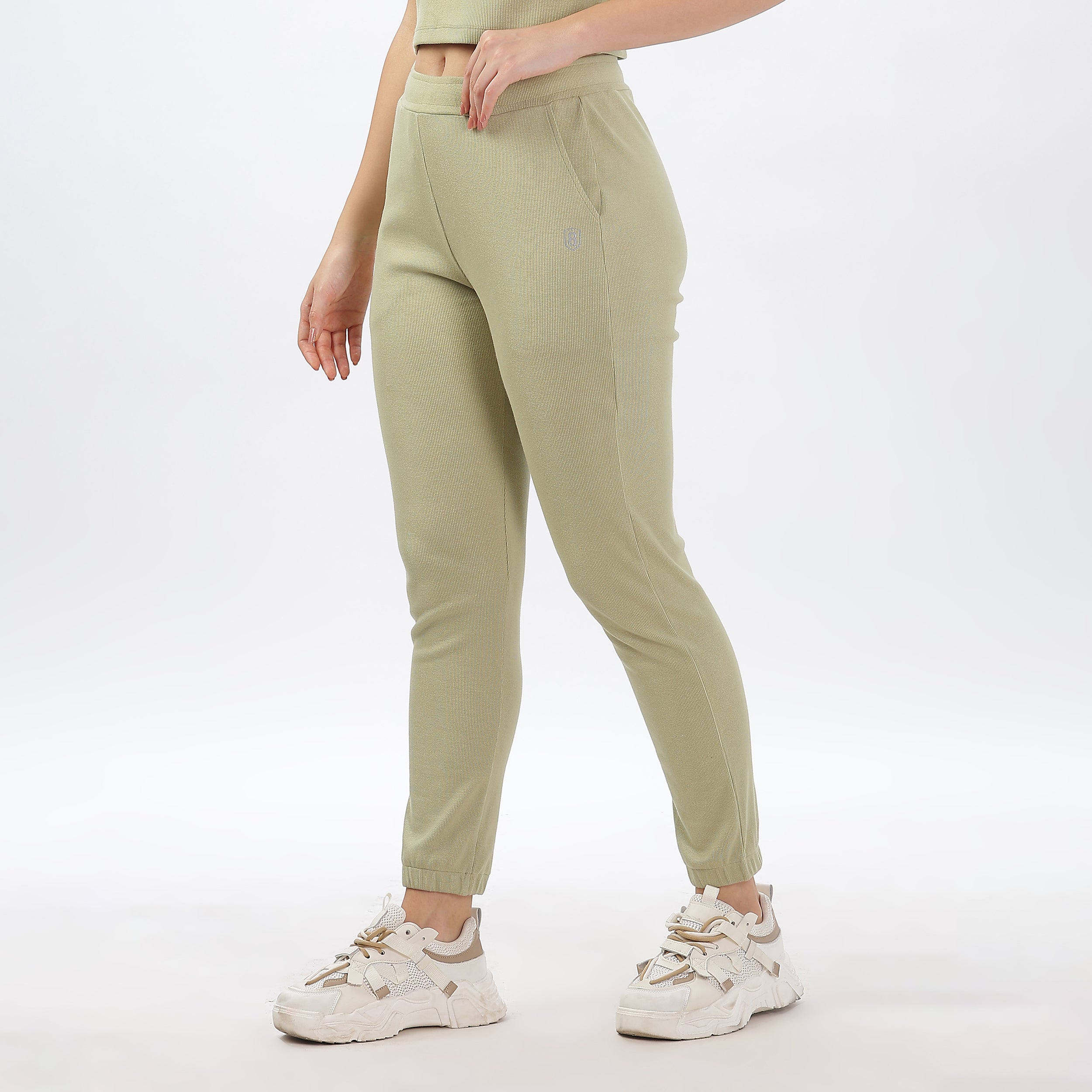 Joggers with elastic waistband and matching crop top in light green, offering a relaxed fit.
