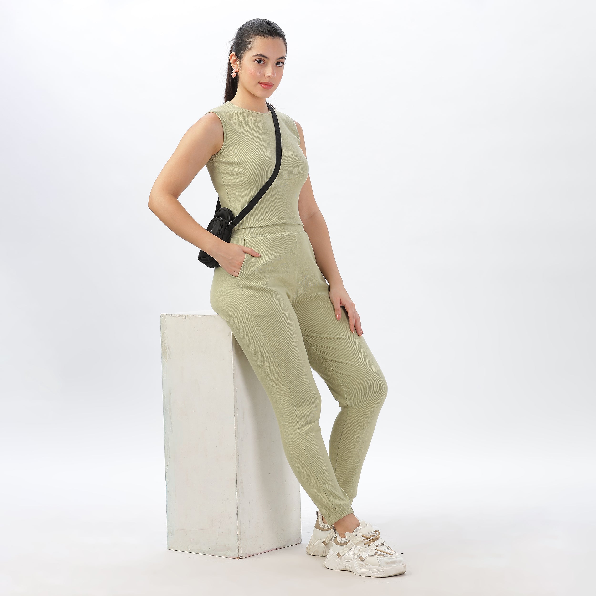 Side view of women’s light green joggers and crop top set, showcasing a flattering silhouette.
